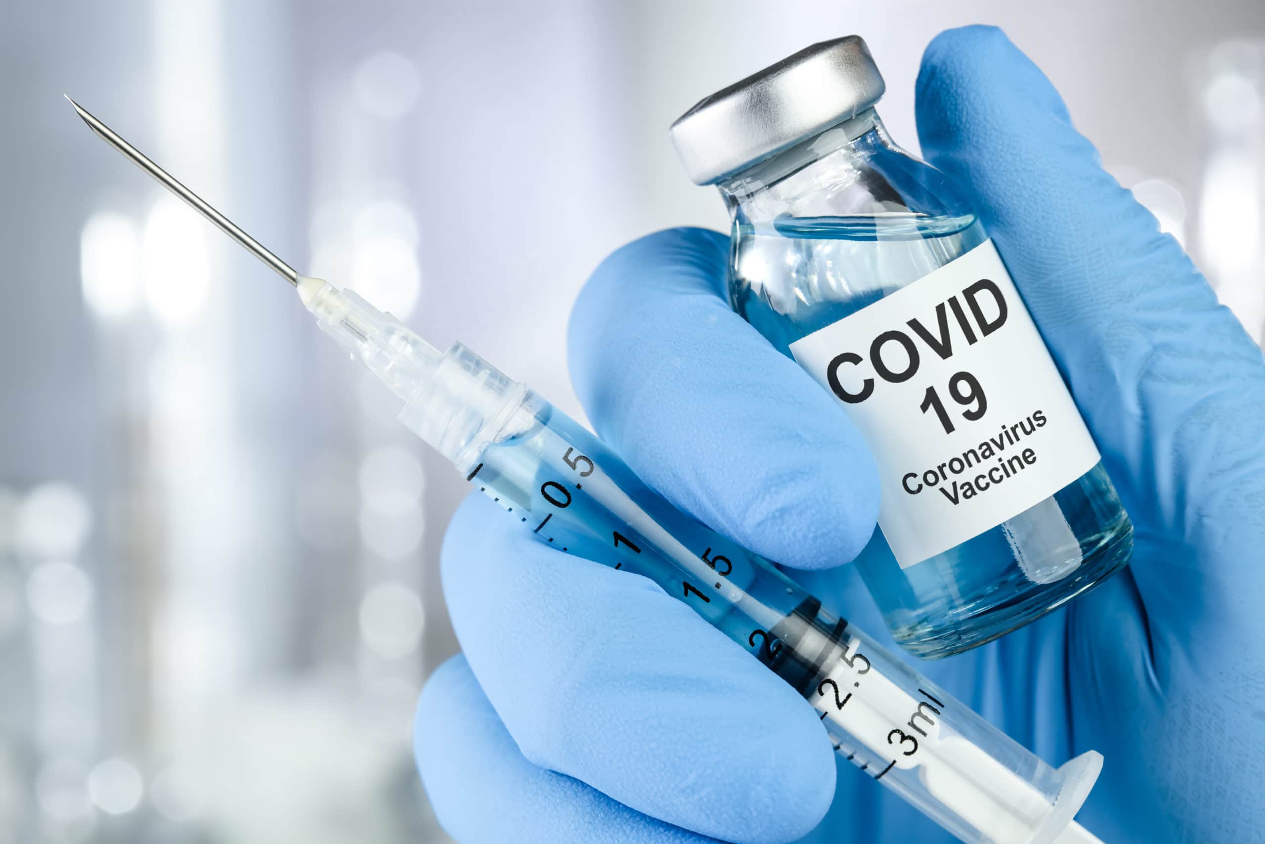 Healthcare with blue medical glove holding Covid 19 virus, vaccine vial